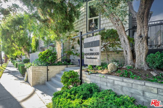 Front view of a townhouse with stairs leading to the entrance.