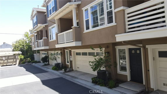Front view of multi-story townhouses with garages and balconies.