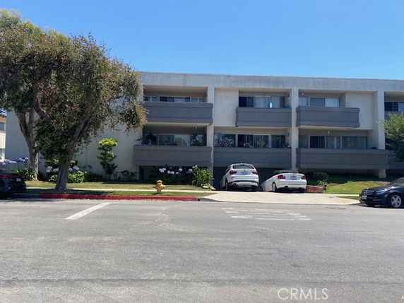 Front view of a multi-story apartment building with balconies.
