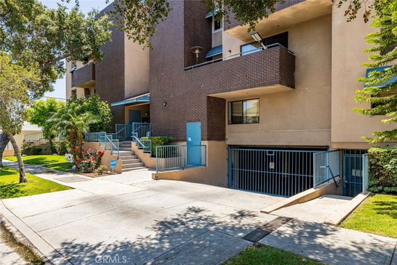 Front view of a multi-story building with balconies and a gated entrance.