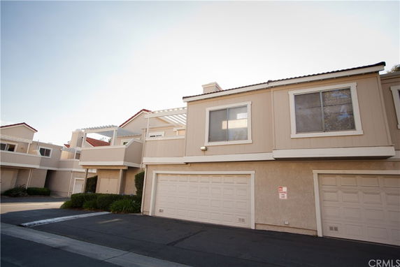 Front view of a multi-story residential building with double garages.