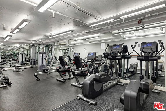 Indoor gym area with various exercise equipment and machines.