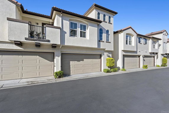 Front view of a row of two-story townhouses with garages.