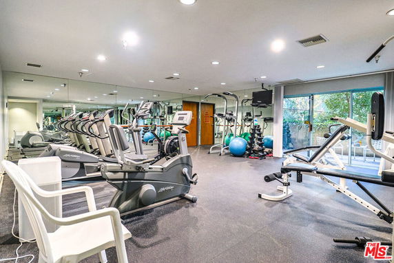 Indoor gym area with exercise equipment and mirrors.