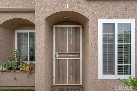 Front entry view of a building with an arched doorway and security door.