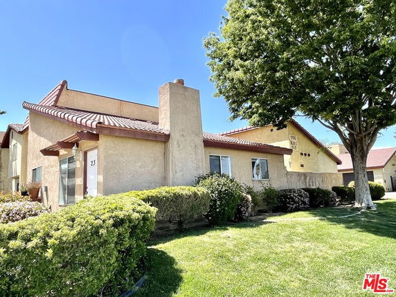 Front view of a single-story house with a sloped roof and chimney.