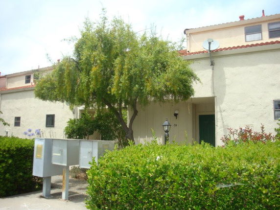 Front view of a two-story building with a flat roof and a satellite dish.