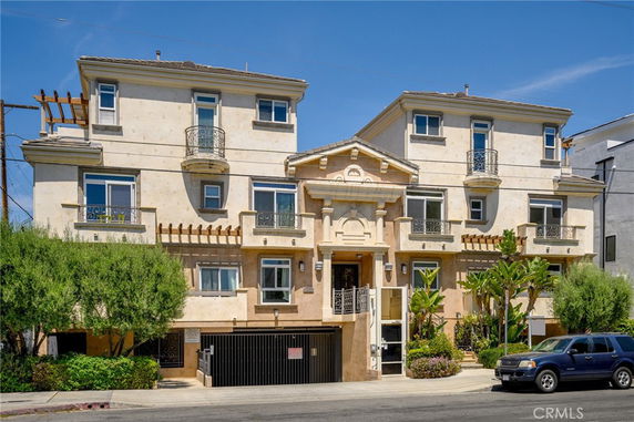 Front view of a multi-story residential building with a decorative facade and balconies.