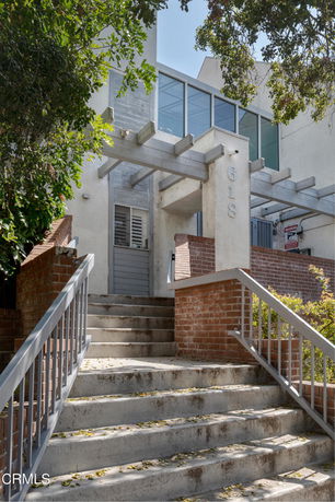Front view of a multi-story building with stairs leading to the entrance.