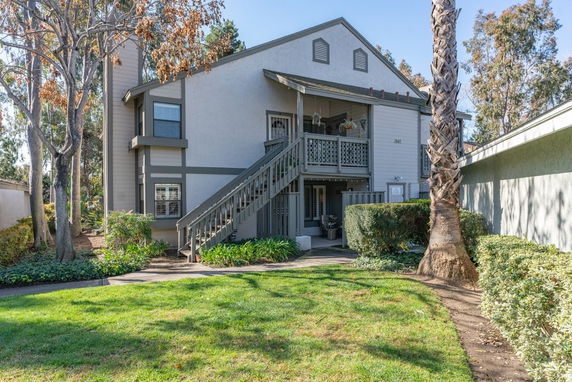 Front view of a two-story residential building with exterior stairs.