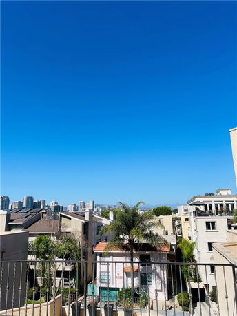 Wide view of cityscape with multiple buildings under a clear blue sky.