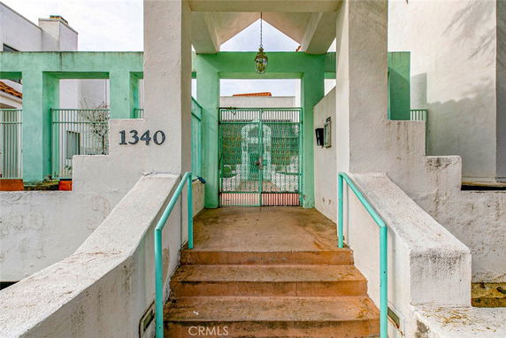 Front view of a building entrance with a walkway and a metal gate.