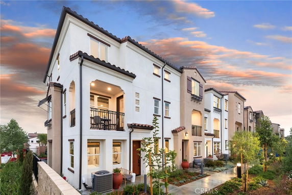Front view of a multi-story house with balconies and a modern design.