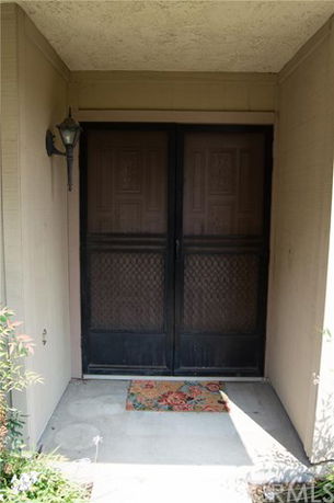 Entrance view of a house with double doors and a porch light.