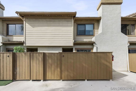 Front view of a two-story townhouse with a fenced entrance.