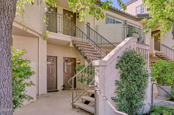 Front view of a multi-story building with staircases and multiple entry doors.
