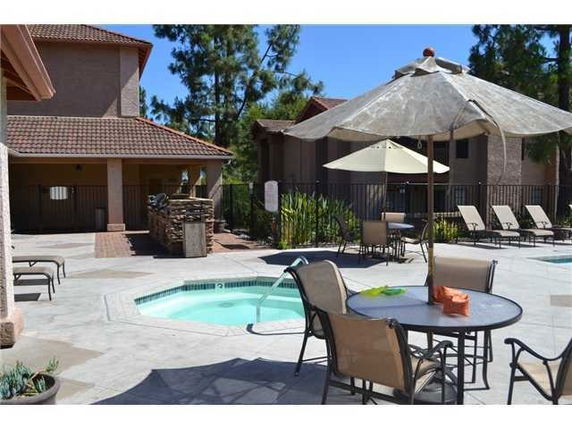 Outdoor area with a hot tub and patio furniture near a building.