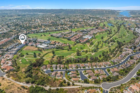 Aerial view of a residential area surrounded by green spaces and a golf course.