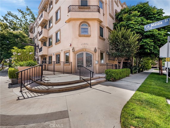Front view of a multi-story building with ornate entrance and metal railings.