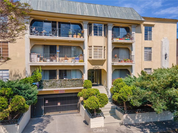 Front view of a three-story apartment building with balconies.