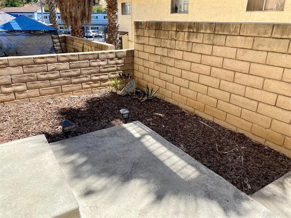 View of a small outdoor area with concrete steps and brick walls.