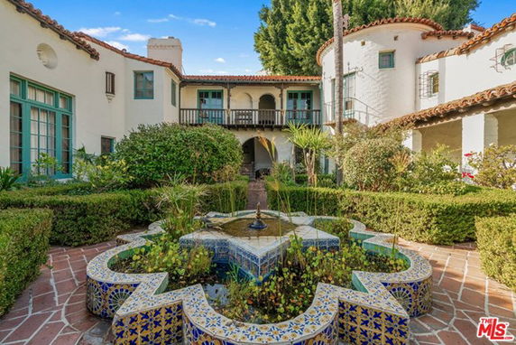 Front view of a two-story house with courtyard and decorative fountain