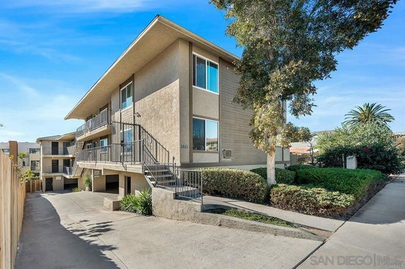 Front view of a two-story apartment building with stairs and balconies.