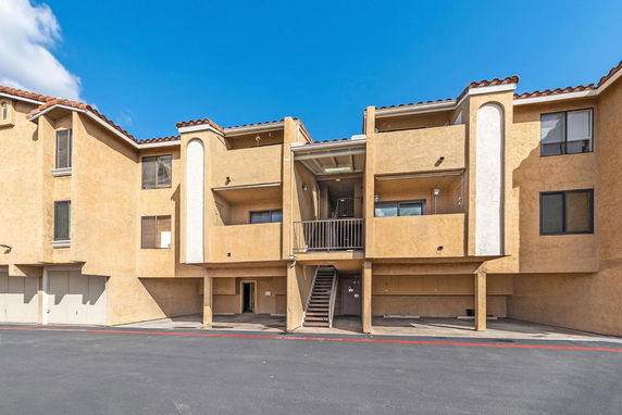 Front view of a multi-story apartment building with balconies.
