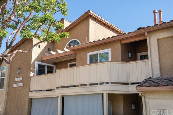 Front view of a multi-story house with a beige exterior and small balcony.