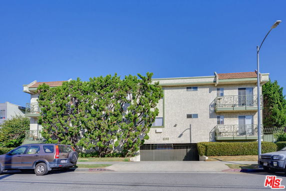 Front view of a two-story building with balconies and a garage entrance.