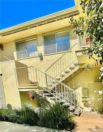 View of an exterior staircase leading to the upper level of a building with large windows.