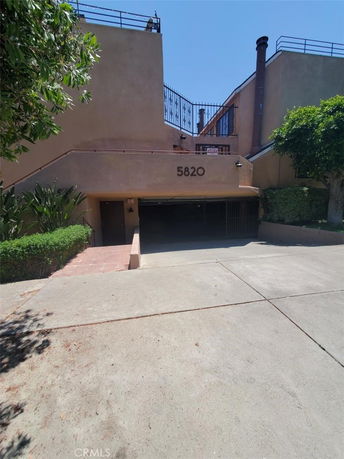 Front view of a multi-story building with a garage entrance and stair access.