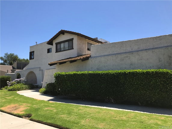 Front view of a two-story house with a tiled roof and stucco walls.