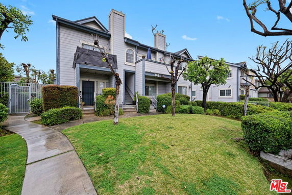Front view of a two-story townhouse with a central chimney.