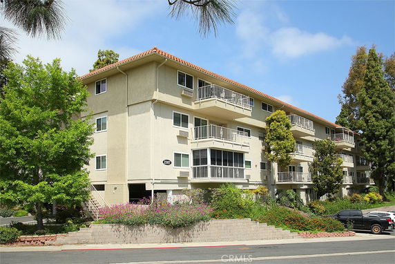 Front view of a multi-story apartment building with balconies.