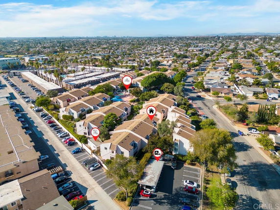 Aerial view of a residential area with multiple houses and nearby parking spaces.