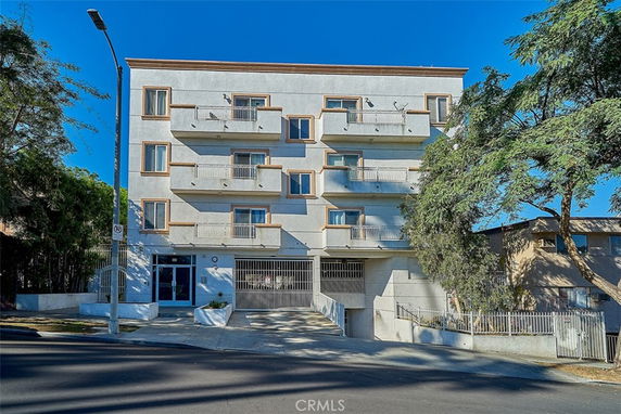 Front view of a multi-story apartment building with balconies.