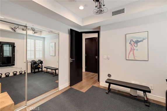 Indoor gym area with a bench, mirrors, and kettlebells.