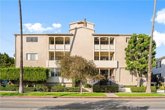 Front view of a multi-story apartment building with balconies.