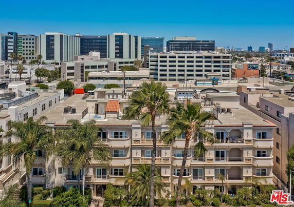 Aerial view of a multi-story building surrounded by other buildings.
