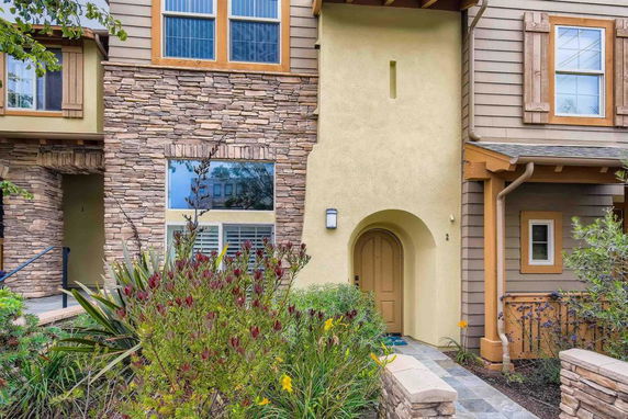 Front view of a two-story house with stone and stucco exterior.