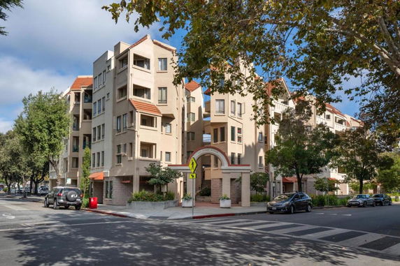 Front view of a multi-story apartment building with red-tiled roofs.