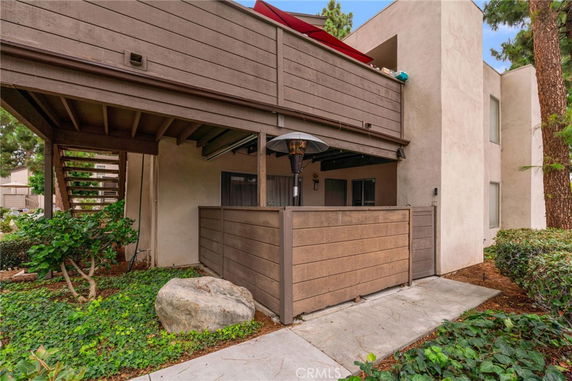 Front view of a multi-story building with a covered patio area and outdoor staircase.
