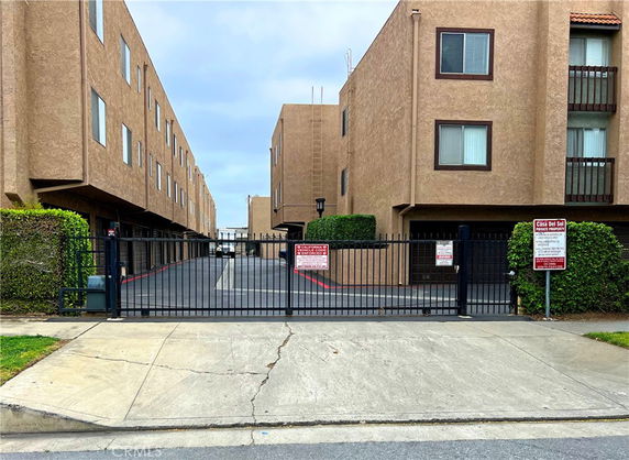 Front view of a multi-story residential building with a gated entrance.