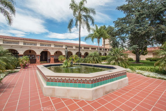 Front view of a building with a fountain and red tile roof.