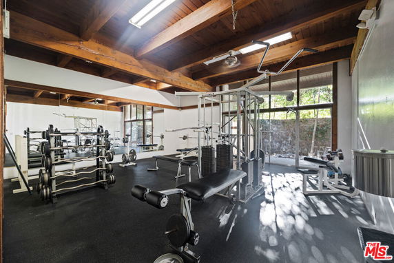 Interior view of a gym area with exercise equipment and mirrors.