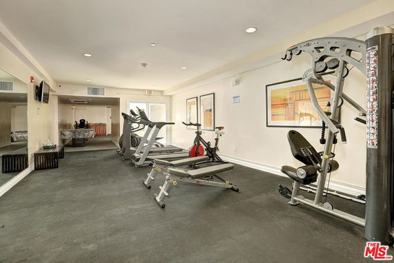 Indoor gym area with exercise equipment including treadmills and weight machines.