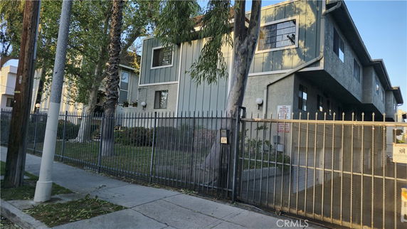 Front view of a two-story building with a gated entrance.