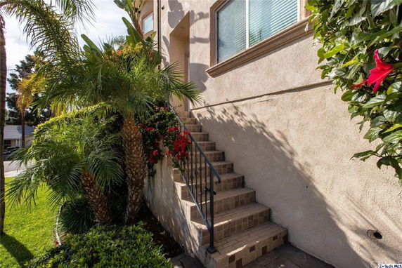 Side view of a house with an outdoor staircase leading to the entrance.