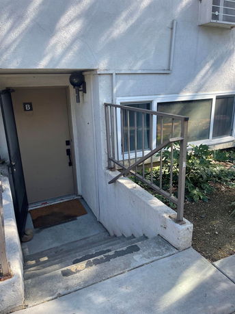 Entrance to a structure with a set of stairs leading down to a door marked with 'B'.